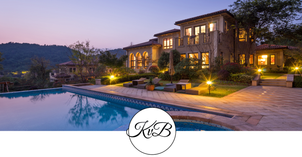 Beautiful mediterranean home with a pool at twilight featuring the Kristen von Bargen logo.